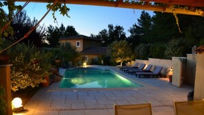 Une piscine avec des chaises longues et une pergola.