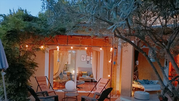 Un espace extérieur aménagé en terrasse, avec des sièges et une lanterne.