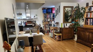 A spacious living room with a dining area, a kitchen, and a bookshelf filled with books. - Excellent Apartment totally renovated, Paris 5th arrondissement (Paris)