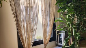 A room with a macramé curtain, a potted plant, and a wine rack. - Excellent Apartment totally renovated, Paris 5th arrondissement (Paris)
