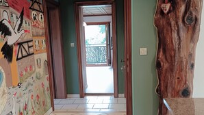 Een hal met een houten plafond, een muurschildering aan de linkerwand en een houten sculptuur aan de rechterkant.