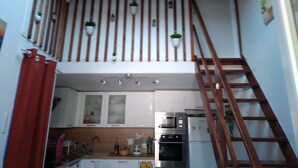 A kitchen with a wooden staircase, a refrigerator, an oven, and a microwave. - Garden floor with mezzanine close to all amenities and the center (Portiragnes)