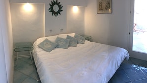 Una camera da letto con un letto, comodini, uno specchio a parete e un quadro incorniciato.