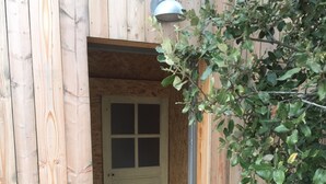 En träbyggnad med en dörr som leder in till ett inre utrymme.