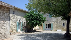 A courtyard with stone buildings, a tree, and a gravel path. - Charming furnished apartment in Mas, UzËs, pool, 656 yards away from town centre (Uzès)