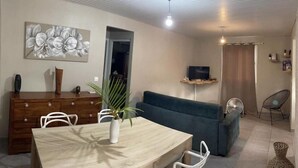 A living room with a dining table, sofa, TV, and a decorative plant. - NEW SUITE COTTAGE F3 ANY COMFORT NEAR BEACH ANSE FIGUIER  (Rivière-Pilote)