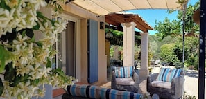 A covered outdoor seating area with wicker furniture and a pergola. - Fully air-conditioned house HEATED SWIMMING POOL  (Maubec)