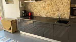Una cocina moderna con protector de piedra, electrodomésticos de acero inoxidable y techo de madera.