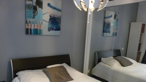 Ein Hotelzimmer mit zwei Betten, einem großen Spiegel und Bildern an den Wänden.