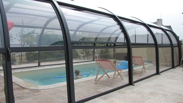 A covered swimming pool area with a glass enclosure, two lounge chairs, and a small inflatable pool. - comfortable house private indoor heated pool 28 ° C 450m sandy beaches (Santec)
