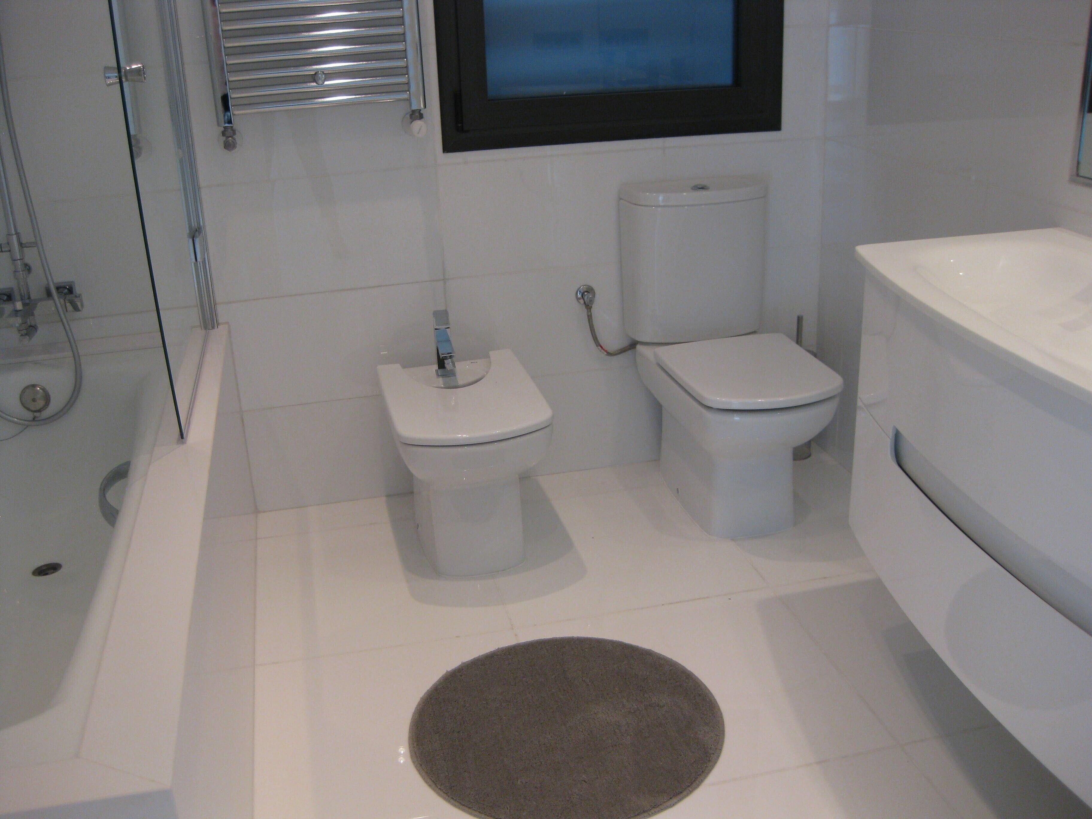 A bathroom with a toilet, bidet, and bathtub.