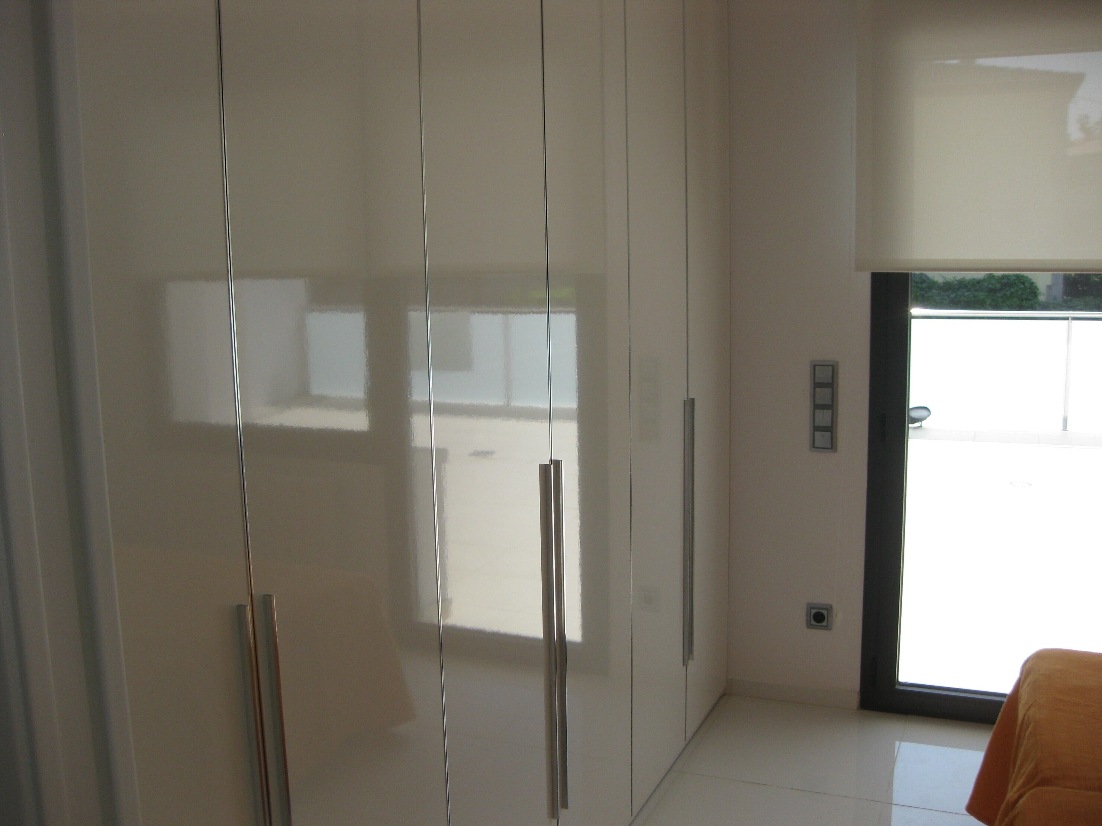 A modern room with a large wardrobe, a door leading to an outdoor area, and a tiled floor.