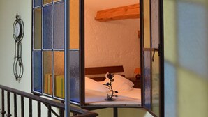 A room with a bed, a nightstand, and a wall-mounted clock. - Autan roses, Character Cottage in Lauragais Auriac / Vendinelle (Auriac-Sur-Vendinelle)