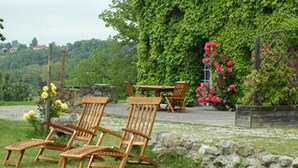 A garden with wooden chairs and a table, surrounded by greenery and flowers. - Autan roses, Character Cottage in Lauragais Auriac / Vendinelle (Auriac-Sur-Vendinelle)