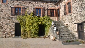 A stone building with arched windows and a staircase leading to an upper level. - Gîte 12 pers, pétanque court, swimming pool : week from july 11th to 18th free ! (Courris)