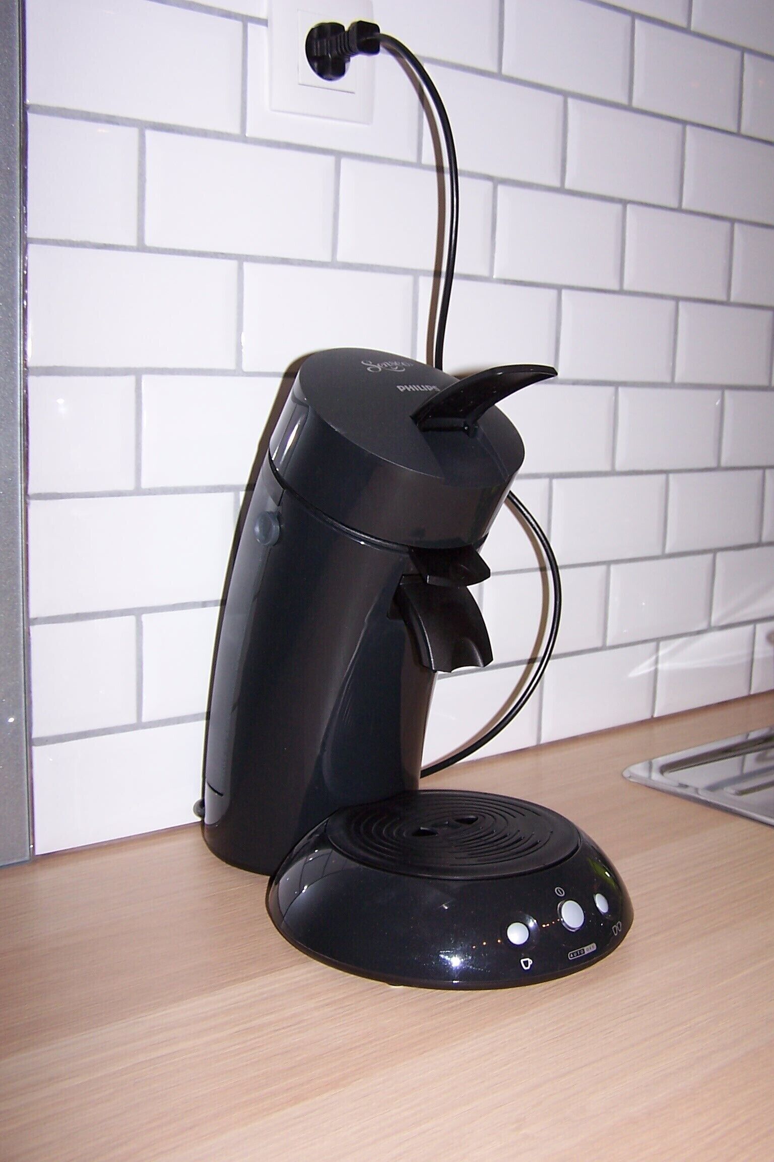 Een zwarte koffiemachine met een bedieningspaneel op een aanrecht.