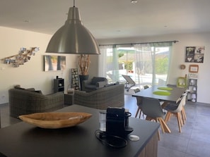 A modern kitchen with a large island, dining area, and a view of the outdoors. - The Mapokia1 air-conditioned villa with private heated pool near Uzés ******. (Saint-Marcel-De-Careiret)