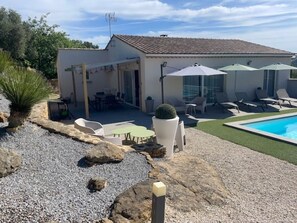 Une maison dotée d’un patio, d’un espace salon extérieur, d’une piscine et d’un jardin.
