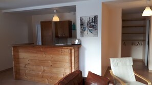 A kitchen with wooden cabinets, a toaster, and a hanging light fixture.