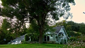 A house with a large tree in front, a basketball hoop, and a garden with flowers. - Private 3-Acre Vineyard Estate with Extraordinary Views (Sebastopol)