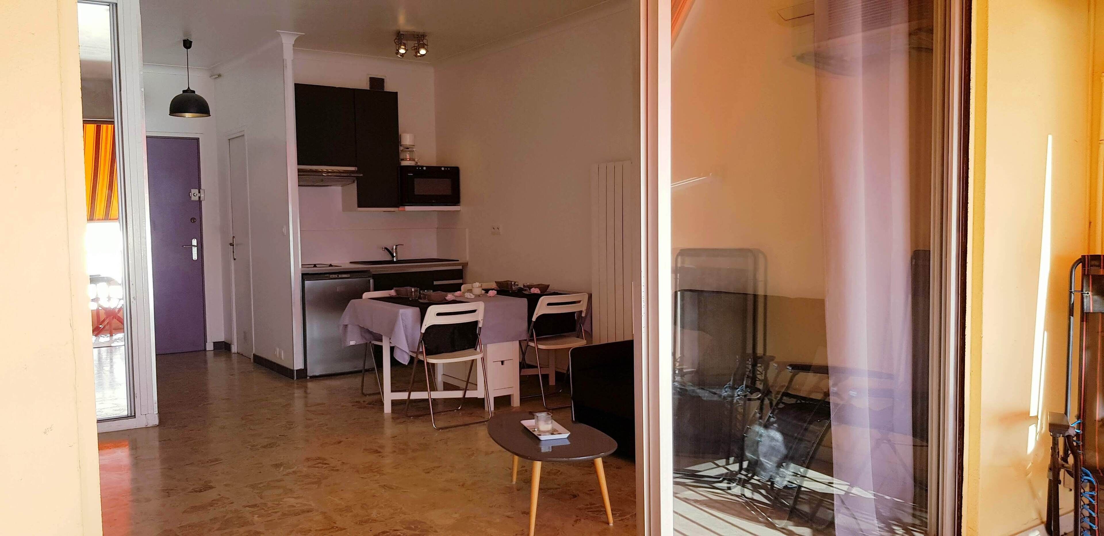 A compact kitchen with a dining area, a small table, and chairs.