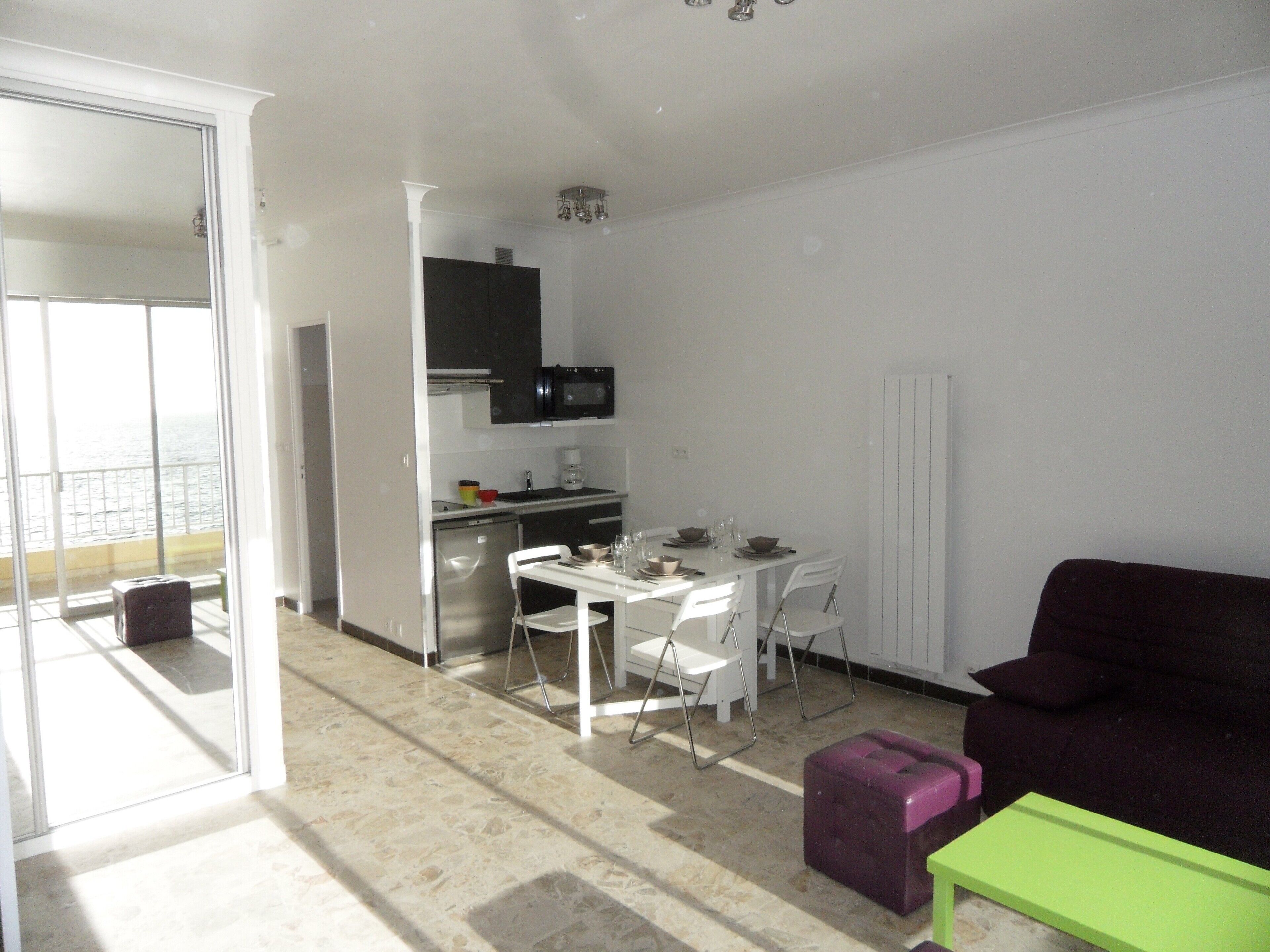 A compact living space with a kitchenette, dining area, and a sofa.