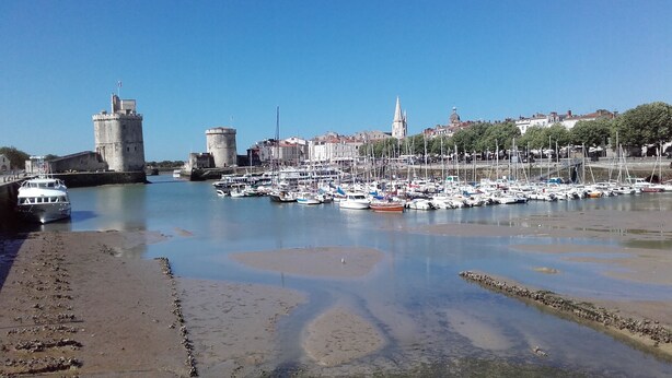A marina with boats docked, a castle, and a town in the background. - House 10km from La Rochelle (Marsilly)