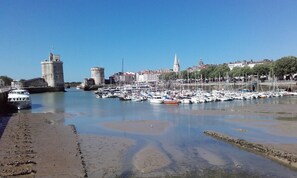 Un port de plaisance avec des bateaux amarrés, un château et une ville en arrière-plan.