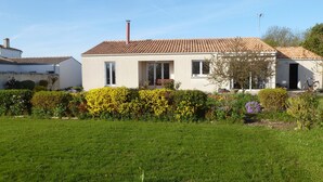 A single-story house with a tiled roof, a chimney, and a front door. - House 10km from La Rochelle (Marsilly)