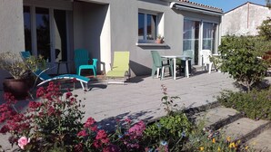 A patio with outdoor furniture, a potted plant, and a small table. - House 10km from La Rochelle (Marsilly)
