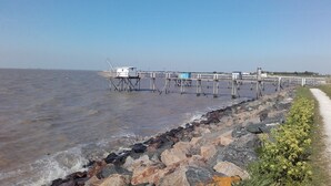A pier extending into a body of water with a rocky shoreline and a path alongside. - House 10km from La Rochelle (Marsilly)