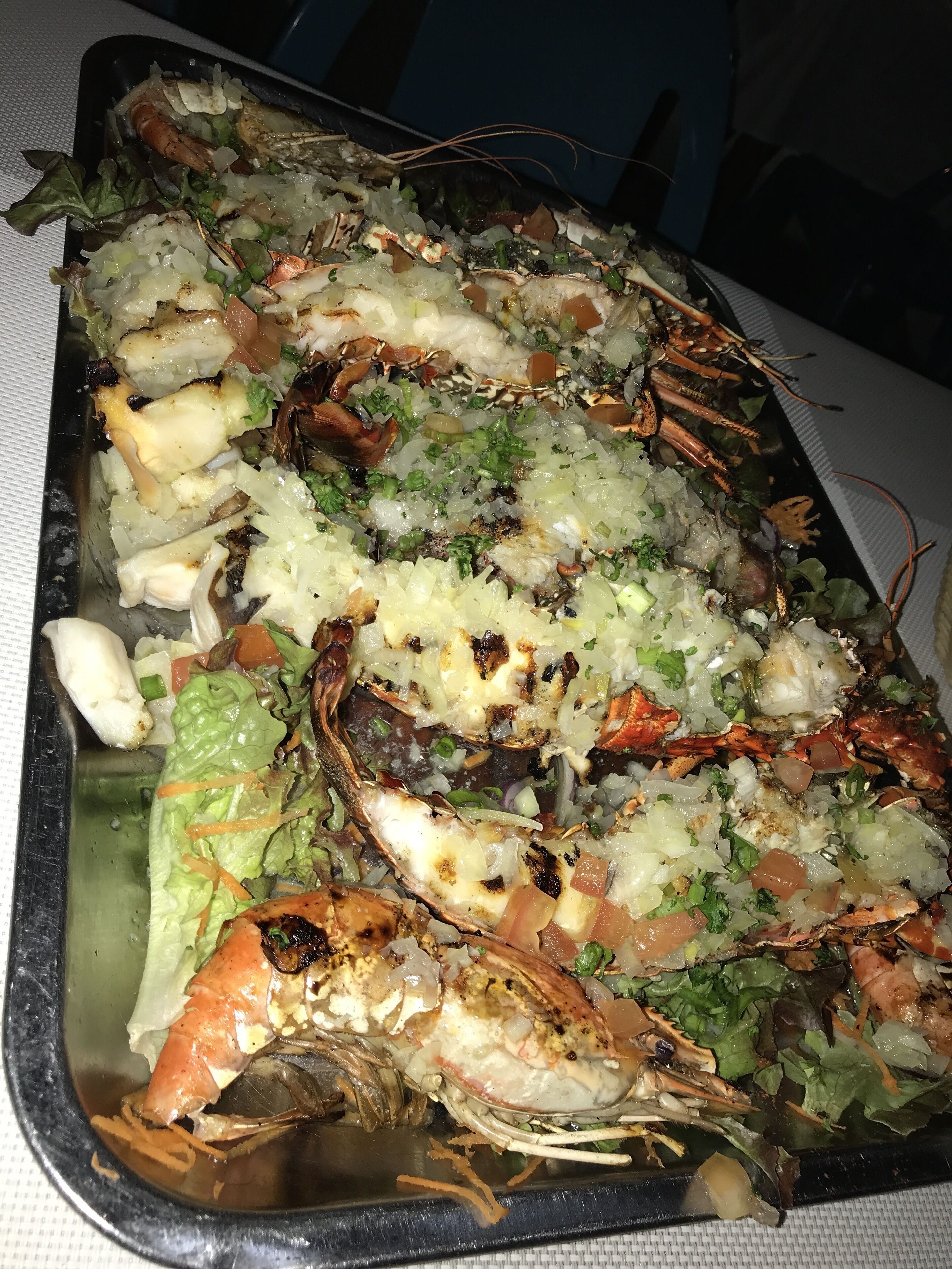 A tray of grilled seafood with vegetables.