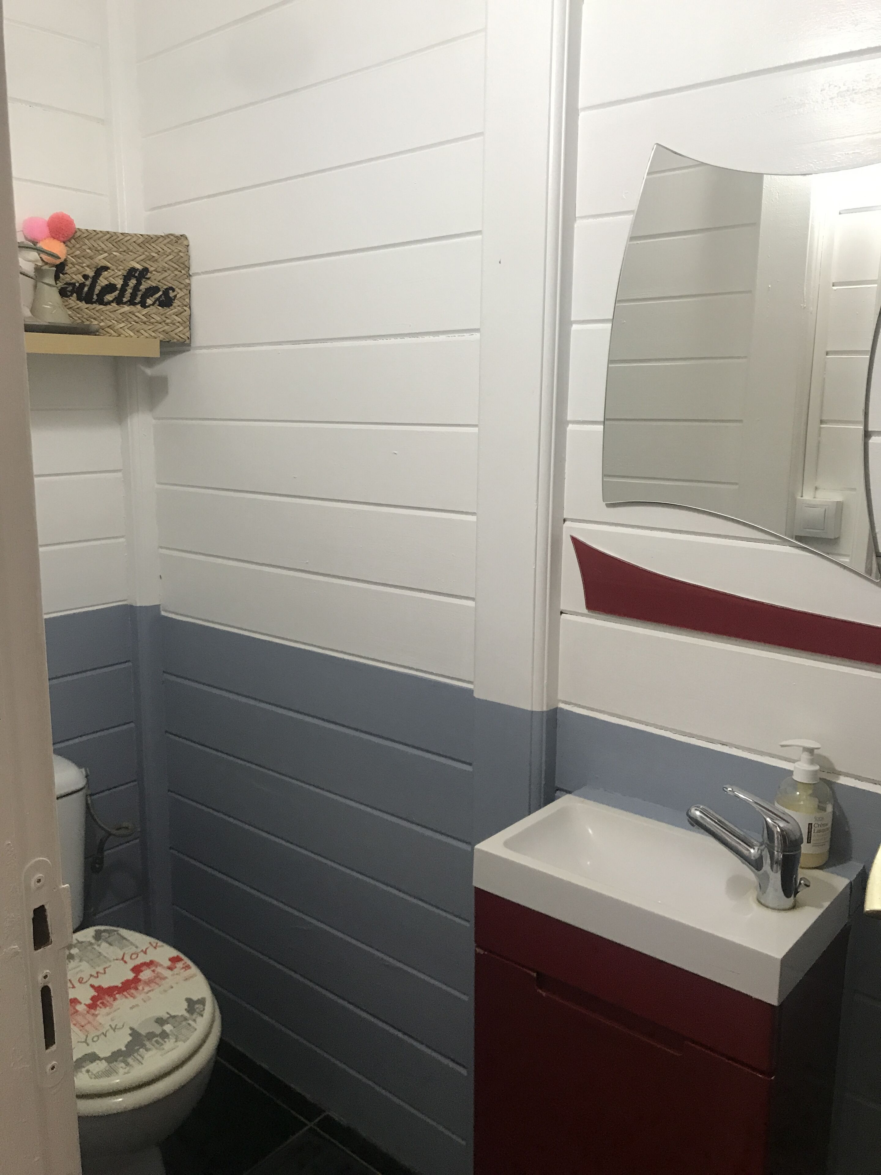 Ein Badezimmer mit Toilette, Waschbecken und Spiegel.