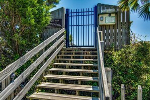A wooden staircase leading to a gated area with signs indicating restricted access to sea cabins and a saltwater fishing license requirement.
