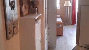 Ett kök med vita skåp, ett kylskåp och en matplats med ett bord och stolar.