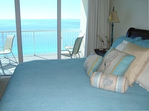 Relax in a serene ocean-view room with a large bed, balcony, and elegant touches.