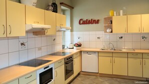 A kitchen with yellow cabinets, a stove, a dishwasher, and a sink.