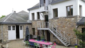 A stone building with a metal staircase leading to a second floor.