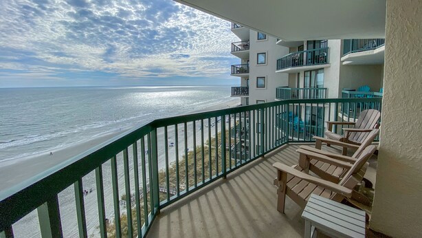 Ein Balkon mit Blick auf Strand und Meer.