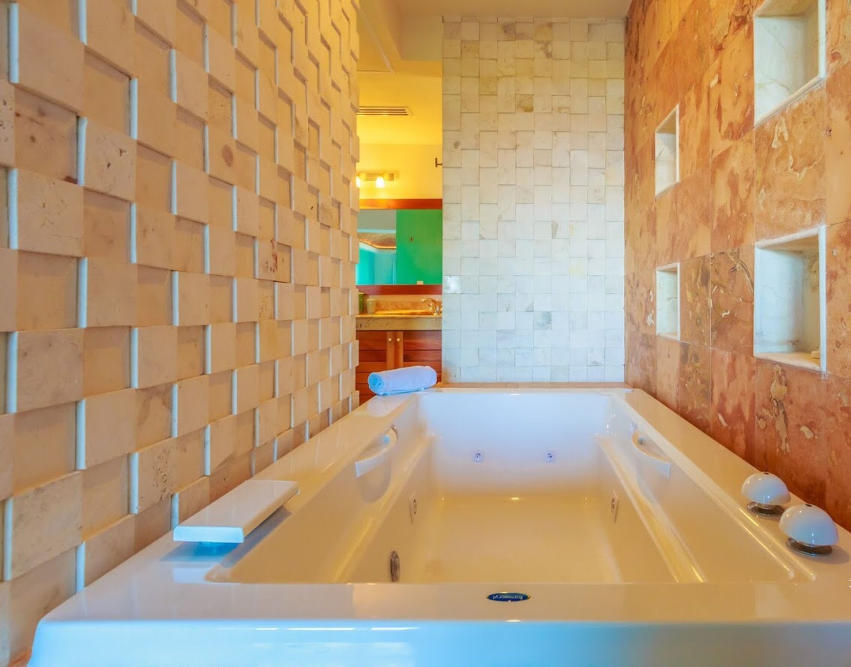 Une salle de bain moderne avec une grande baignoire, des murs carrelés et un espace douche bien délimité.