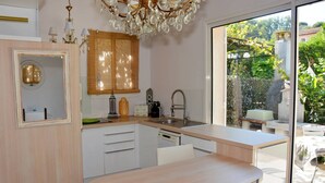Une cuisine moderne dotée d’une grande fenêtre, d’un coin repas et offrant une vue sur le jardin.