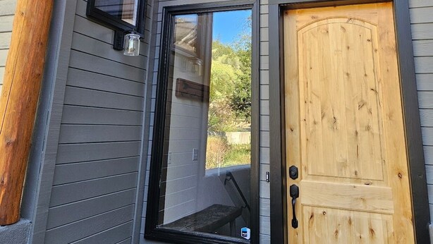 A wooden exterior with a gray siding house, a door, and two windows. - Sage Haven Welcomes EIGHT to TEN Guests. Let the Sun Valley Adventures Begin! (Ketchum)
