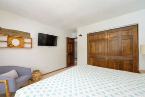 A bedroom with a bed, a television, a wooden wardrobe, a sofa, and a wall-mounted TV stand. - Spectacular 11BR Mountain Home for Large Groups (Fraser)
