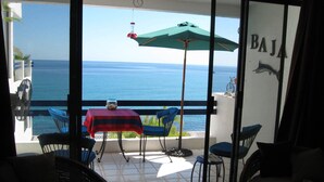 A balcony with a table, chairs, and a view of the sea. - Beachfront Condo, Summer Special, 154 u.s.  per night!!!!!!! (Beauna Vista)