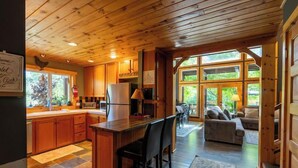 A spacious kitchen with wooden cabinets, a central island, and a dining area with a sofa and chairs.