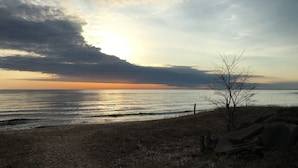 Een strand met een helder uitzicht op de oceaan en een zonsondergang.