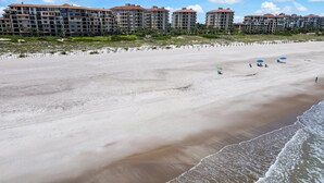 Une plage avec, en arrière-plan, une rangée d’immeubles à plusieurs étages.