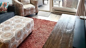A living room with a sofa, armchair, and a wooden coffee table.