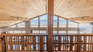 A wooden interior with a high ceiling and large windows overlooking a beach. - Ocean Views for days.....Oceanfront property that will leave you breathless! (Cloverdale)