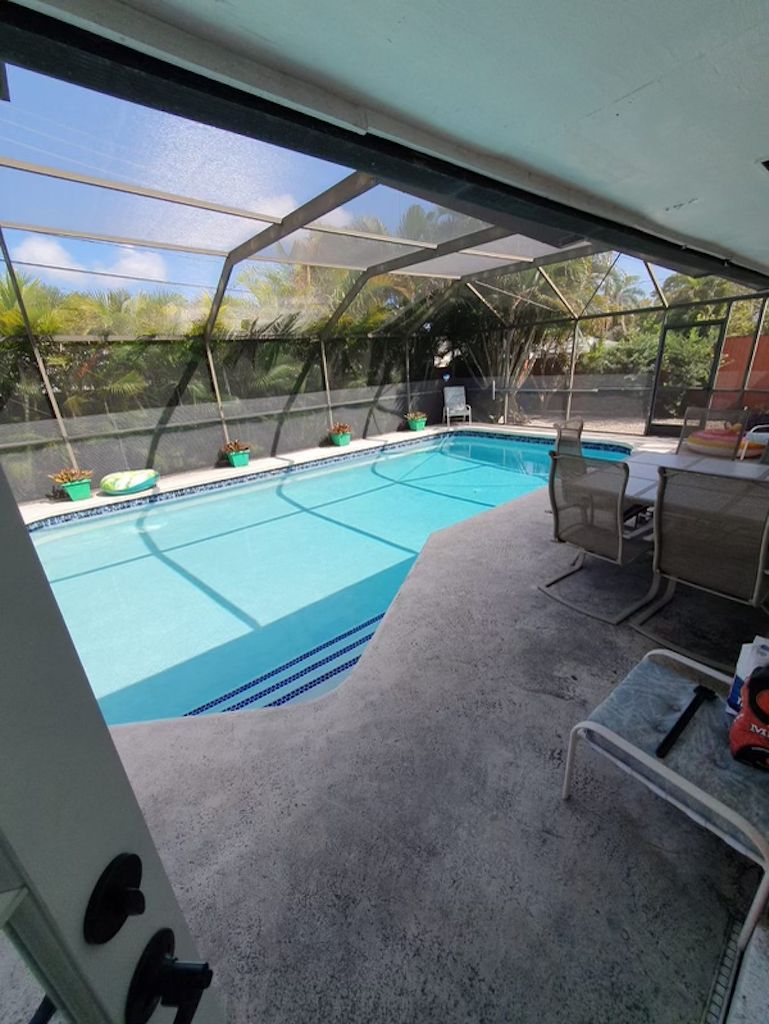 En swimmingpool med et overdækket område og en terrasse.